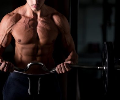 Muscular man lifting a barbell in gym