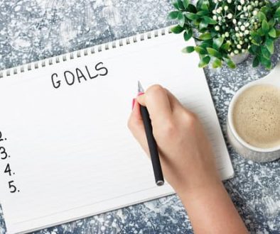 Female hand writes goals in a notebook, planning concept
